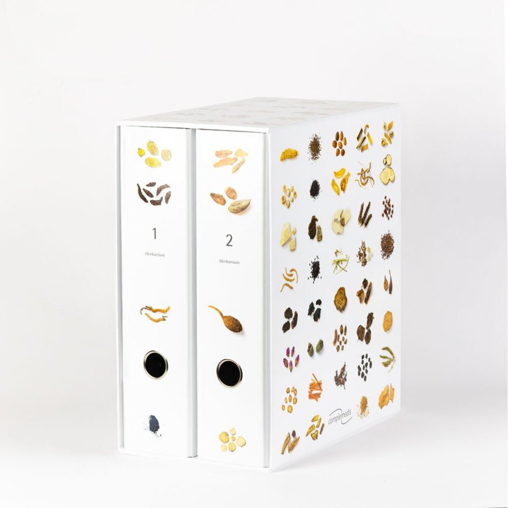 Zwei Ordner des Herbariums der chinesischen Medizin mit farbenfrohen Kräuterabbildungen.