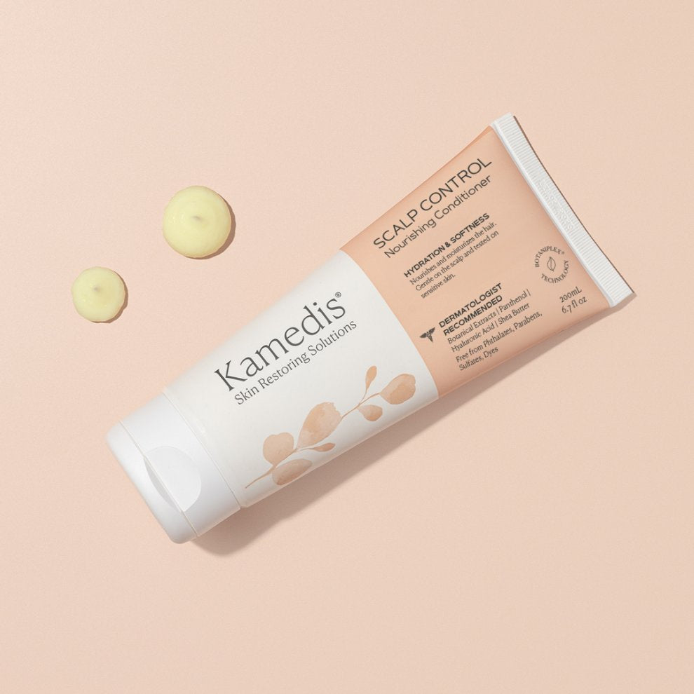 Kamedis Scalp Control Nourishing Conditioner Tube à 200 ml liegend auf pastellfarbenem Hintergrund mit zwei kleinen Portionen Conditioner-Creme daneben.