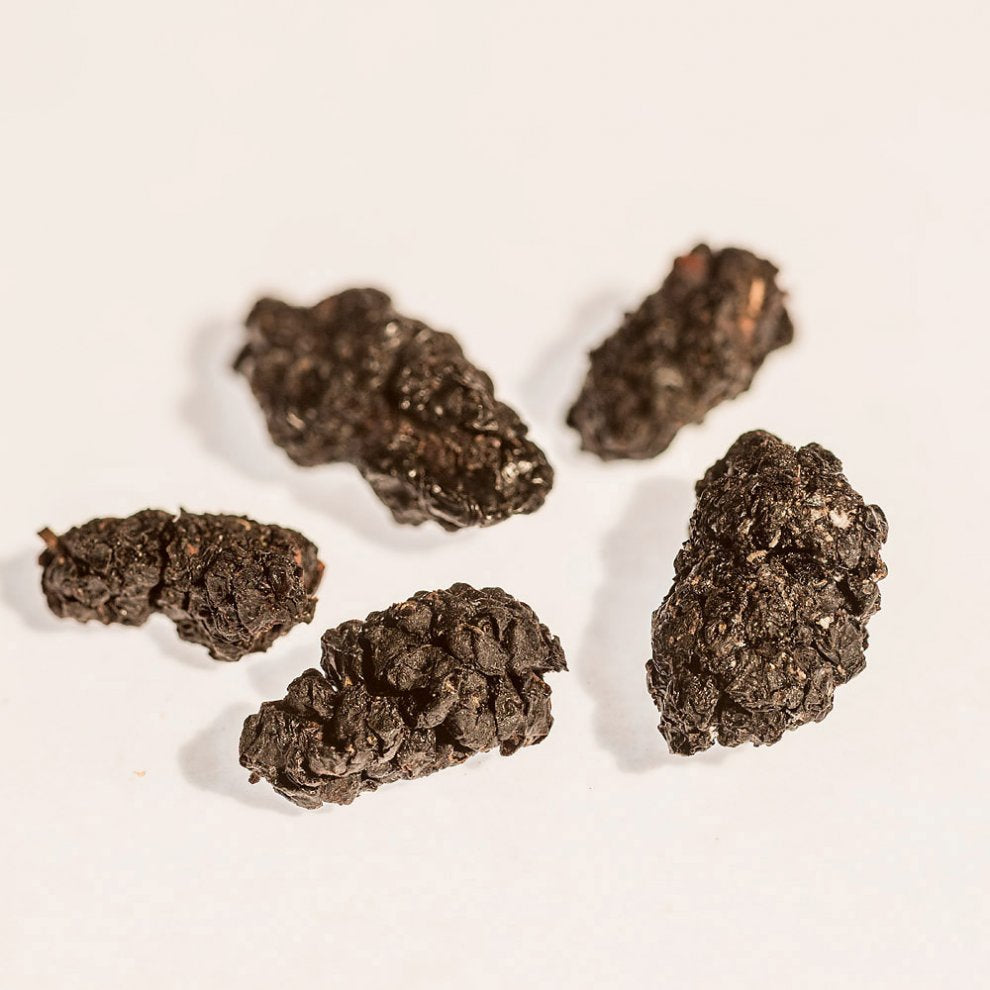 Getrocknete schwarze Maulbeeren auf weißem Hintergrund.